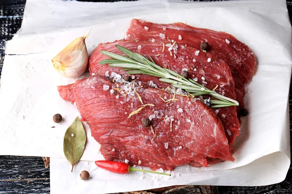 Stuk van rauw vlees met specerijen zout peper knoflook-rozemarijn — Stockfoto