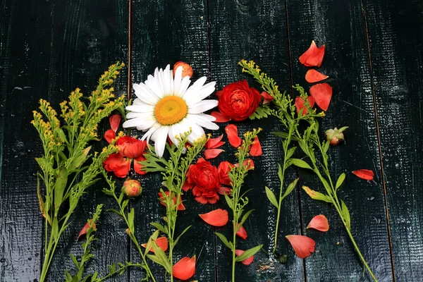 Blumen Zusammensetzung Overhead-Ansicht auf dunklem Holzhintergrund alten Stil flache Gänseblümchen Hahnenfuß asiaticus — Stockfoto