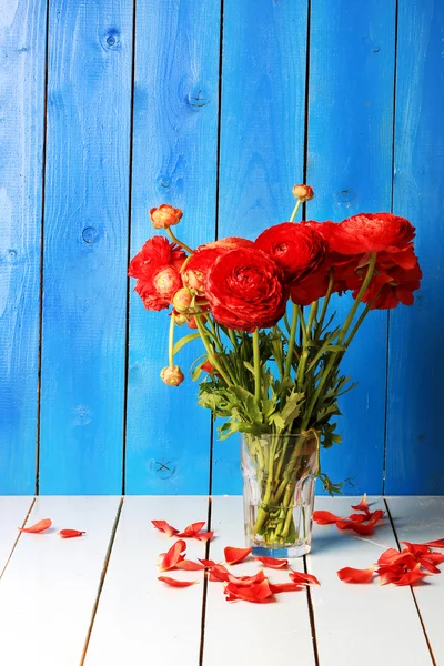 Bouquet Ranunkulyus di fiori rossi su uno sfondo di legno — Foto Stock