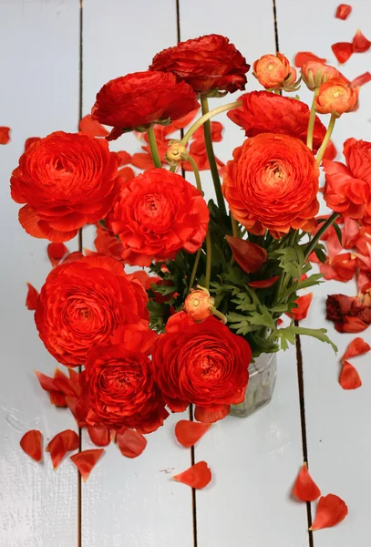Ahşap arka plan tebrik kartı üzerinde kırmızı çiçekler buket Ranunkulyus