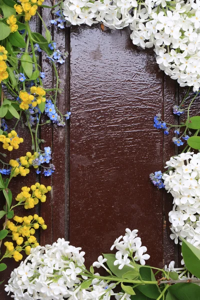 Frame of spring flowers on a wooden background retro vintage style flat lay, overhead view