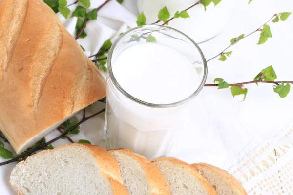 Milch und Brot auf weißem Spitzenhintergrund Bio-Bioprodukt frisches Gebäck gesunder Lebensstil — Stockfoto