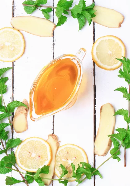 ginger honey lemon mint on a white wooden background ingredient
