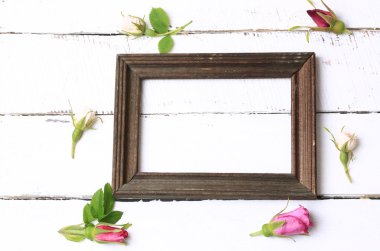 beyaz ahşap arka plan retro shabby şık üst görünümü nde fotoğraf rosebuds için boş çerçeve