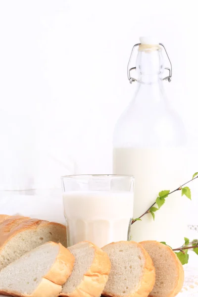 Milch und Brot auf weißem Spitzenhintergrund Bio-Bioprodukt frisches Gebäck gesunder Lebensstil — Stockfoto