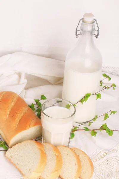 Milch und Brot auf weißem Spitzenhintergrund Bio-Bioprodukt frisches Gebäck gesunder Lebensstil — Stockfoto