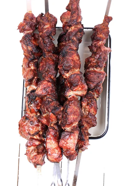 Barbecuepinnen boven op een witte houten achtergrond bekijken bovenaanzicht ondiepe scherptediepte — Stockfoto
