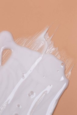Kozmetik doğal pastel kavramı. Bej arkaplandaki sıvı kremin dokusu.