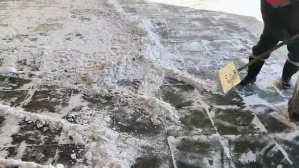 Ein Arbeiter Räumt Mit Einer Schaufel Schnee Auf Der Straße — Stockvideo