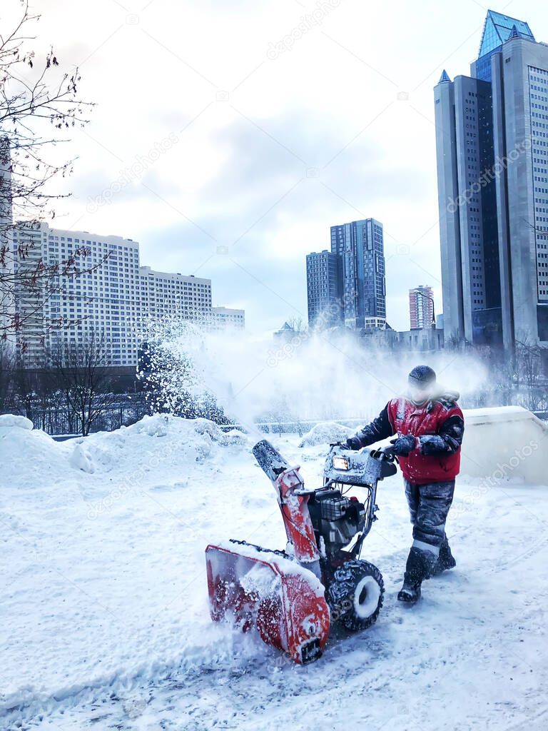 worker removes snow in the city with a snowplow. mobile photography