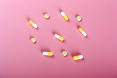 Pembe arka planda sarı haplar