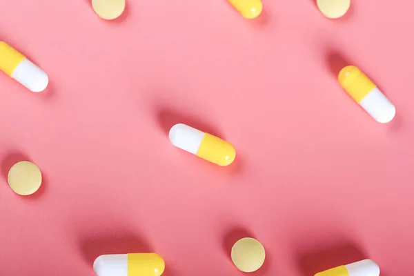 yellow pills pills on a pink background