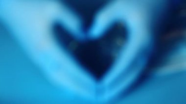 Eldivenlerdeki doktorun elleri kalbin şeklini gösteriyor. Doktorlara sevgi ve minnettarlık.