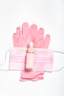 Pembe eldivenler, yüz maskesi ve dezenfektan. Sağlık için kadın hijyen kiti
