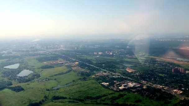 Vista da cidade durante a decolagem da janela do avião. O avião está a ganhar altitude. A filmar através do pórtico. — Vídeo de Stock