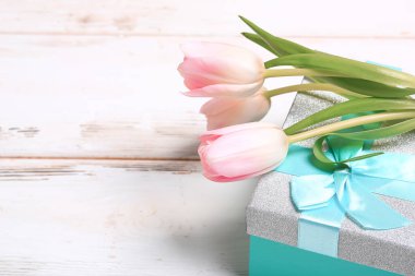 Turkuaz hediye kutusunda zarif pembe laleler.