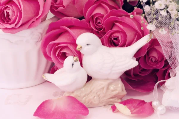 Figurines wedding doves in love Valentine bouquet of pink roses on old books floral background is love tenderness vintage retro selective soft focus — Stock Photo, Image