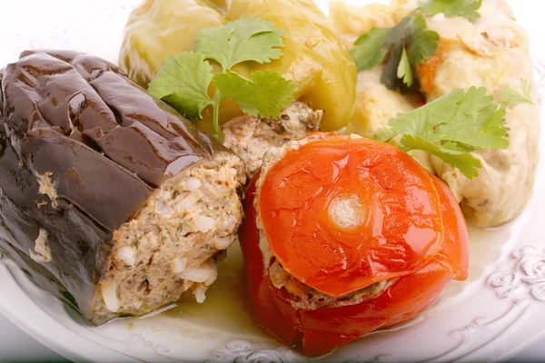 Gevulde aubergine peper tomaat koolbladeren vleespuree met rijst en groen op een witte achtergrond — Stockfoto