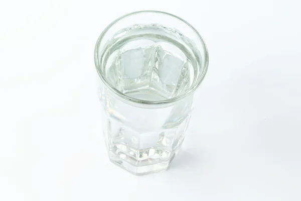 Склянка води ізольована на білому фоні органічний виробляє м'який вибірковий фокус — стокове фото