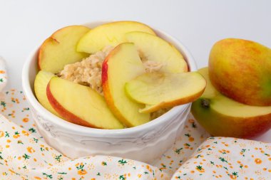 Kahvaltı yulaf lapası ile bir beyaz seramik kase shabby chic retro vintage sağlık diyet seçici yumuşak odak içinde elma