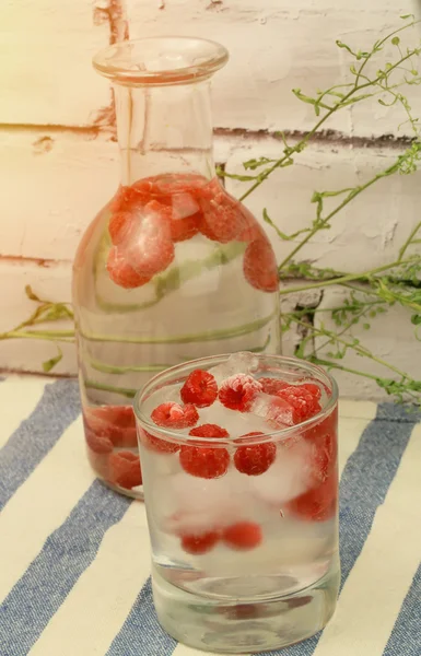 Cold water with frozen raspberries and ice summer hot — ストック写真