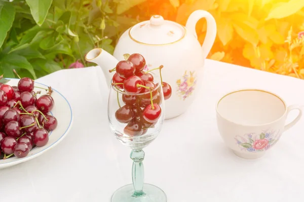 Mesa de vidro de xícara de chá de cereja em um pátio de jardim para toalha de mesa de verão foco suave seletivo — Fotografia de Stock