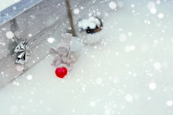 Ange de Noël avec une boîte de coeur avec un cadeau sélectif neige soft focus — Photo