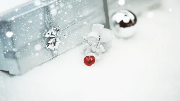 Christmas angel with a heart box with a gift selective snow soft focus — Stock Photo, Image