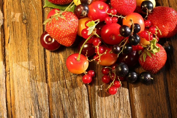 Смесь свежих летних ягод на старом деревянном фоне — стоковое фото