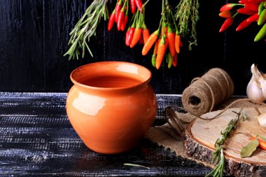 toprak kap karanlık eski ahşap arka plan üzerinde sıcak biber kavurma için retro vintage tarzı baharat