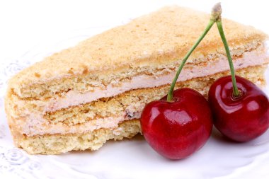 beyaz zemin üzerinde bir kiraz ile pasta