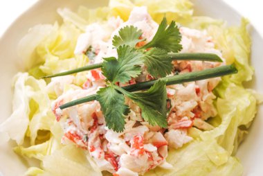 Deniz ürünleri salatası yeşil soğan ve maydanoz ile tepesinde