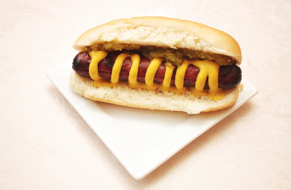 Hot Dog servi avec de la moutarde jaune et des reliques marinées — Photo