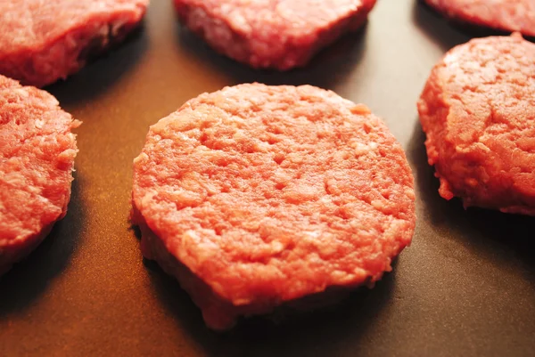 Schuifregelaar Hamburgers koken op een grillplaat — Stockfoto