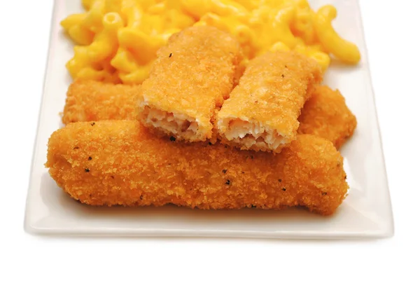 在背景中与 mac 和奶酪一起在盘子上服务的鸡或鱼的棍子 — 图库照片