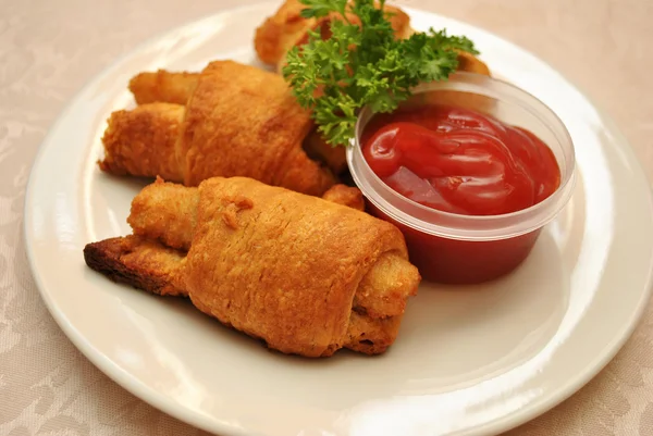 Palos de pescado envueltos en rollos de croissant dorado servidos con Catsup —  Fotos de Stock