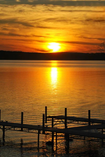 Coucher de soleil coloré donnant sur un quai de bateau sur un grand lac — Photo
