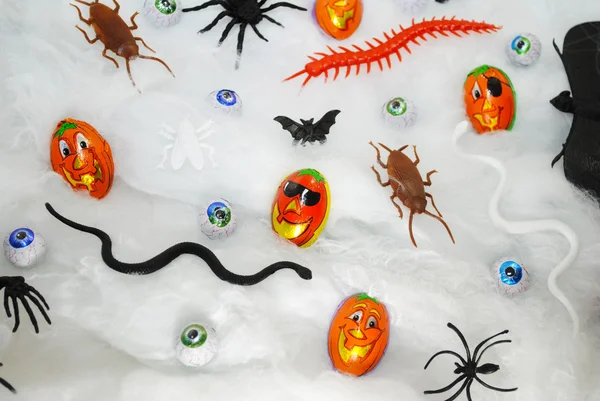 Verschiedene Halloween-Bonbons und Spielzeuge auf einem Gurtband-Hintergrund — Stockfoto