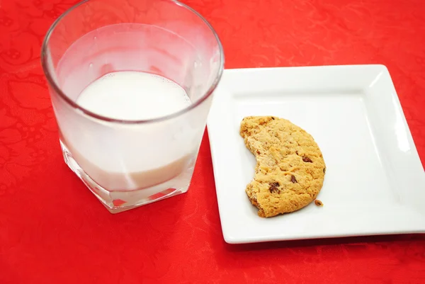 Half Eaten Cookie with an Almost Empty Glass of Milk — Stock Photo, Image