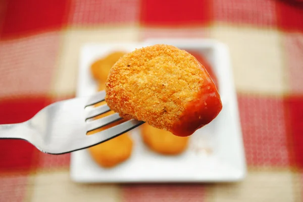 Comer un pepita de pescado o pollo de un tenedor — Foto de Stock