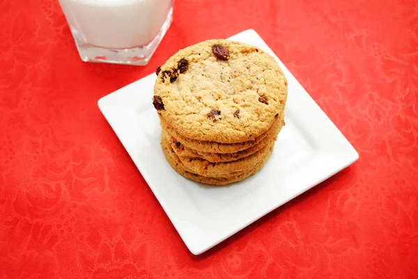 Ovesné korintská cookie na bílé desce s mlékem — Stock fotografie