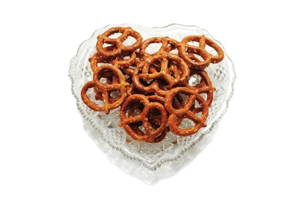 Pretzels em uma tigela de vidro em forma de coração — Fotografia de Stock