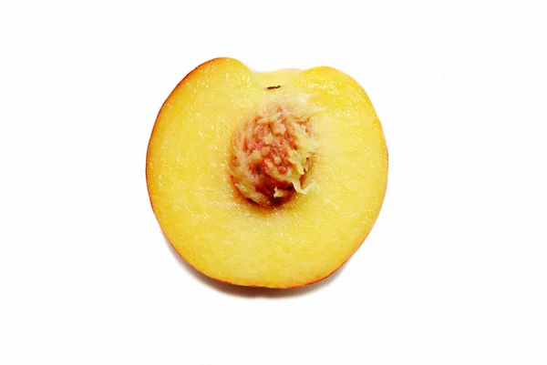 A Peach Cut in Half Isolated Over a White Background — Stock Photo, Image