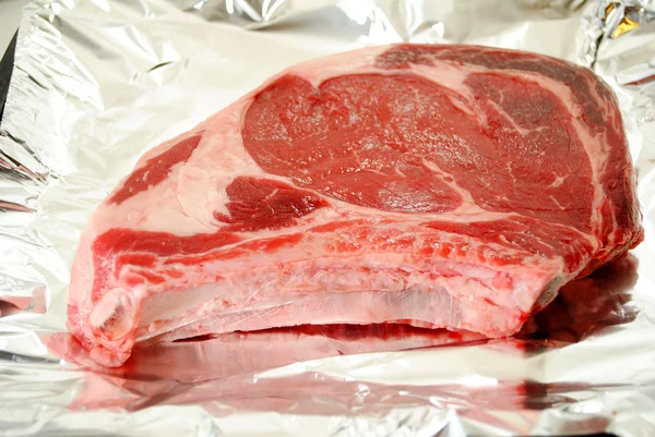 Rauwe biefstuk op folie klaar om te worden geroosterd — Stockfoto
