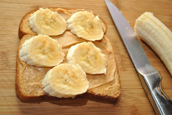 Preparación de un sándwich de plátano y mantequilla de maní — Foto de Stock