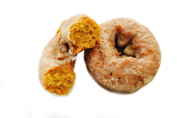 Metade de um donut de abóbora apoiando-se em um donut inteiro — Fotografia de Stock