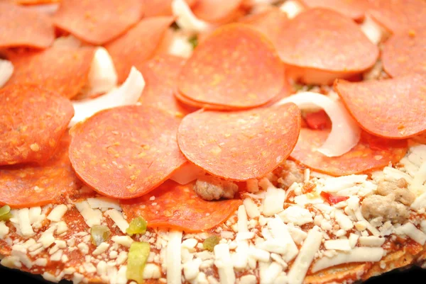 Un montón de pepperoni en un pastel de pizza crudo —  Fotos de Stock