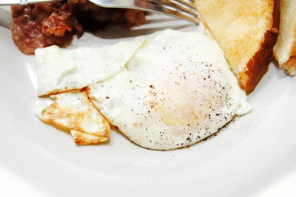 Перец над легко жареным яйцом — стоковое фото