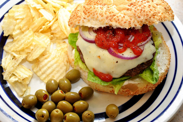 Чипсы с бургером на летнем пикнике
