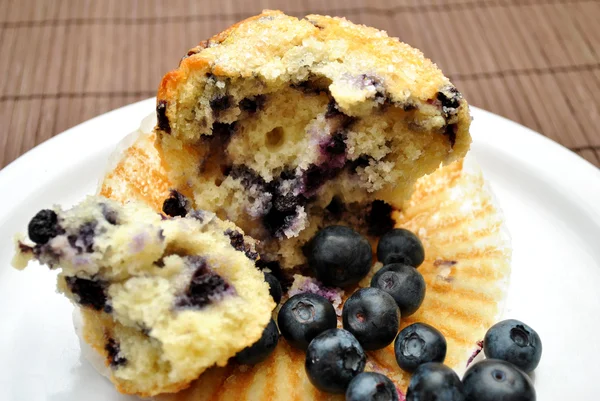 Mirtilli freschi con un muffin mezzo mangiato — Foto Stock